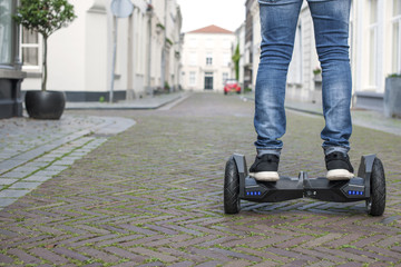 Modern technology, a man is riding on a blackboard. Close Up of Dual Wheel Self Balancing Electric...