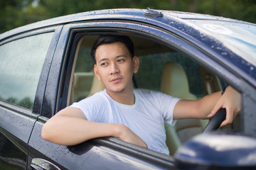 Close up of a handsome Asia man siting in his car.Travel concept..