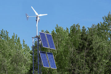 Wind generator and solar panels in the forest. Concept: renewable energy.