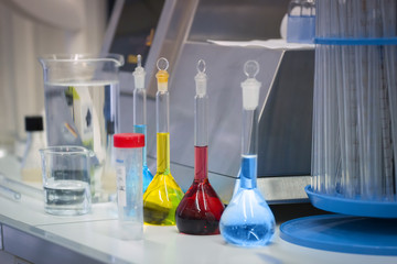 Reagents in colorful flasks are on the table in the laboratory