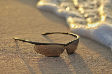 lentes de sol sobre la arena en la playa