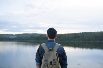 Fototapeta premium back view portrait of young man with backpack standing on the road