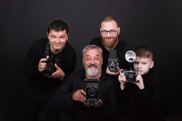 A group of men of different ages, a boy and men holding cameras. The concept of a hobby and study in a photo school © nidvoray