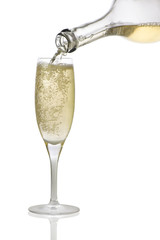 in a glass pour champagne from a bottle on a white background