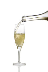 in a glass pour champagne from a bottle on a white
