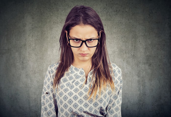 Young serious angry woman in glasses