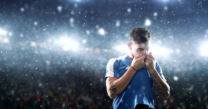 Happy soccer player on a football stadium