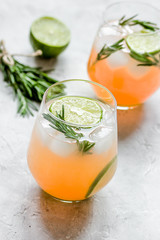 fitness cocktail in glass with lime and rosemary on stone table 