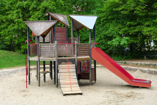 Children Playground With A Wooden Structure And Red Toboggan