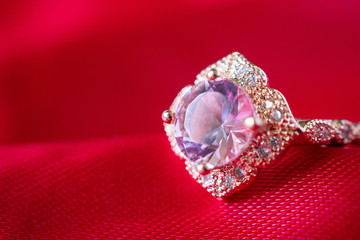 Jewelry luxury pink gold ring with sapphire gemstone on red fabric texture background