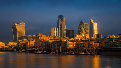 Fototapeta na wymiar London, England - Amazing dramatic sky and golden hour sunlight at Bank District of London with famous skyscrapers