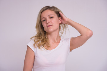 Fototapeta premium portrait of a beautiful blonde girl on a white background in different poses with different emotions.