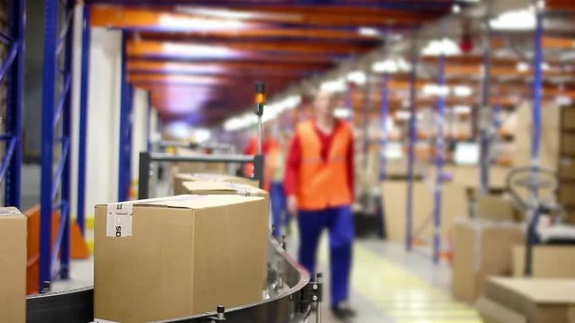 Cardboard boxes On Conveyor Belt In Distribution Warehouse