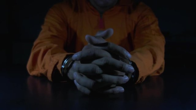 The suspect wear prisoner cloths was arrested at the investigation, interview to find out the truth, the thief was caught by the police come to the dark room,Thailand people