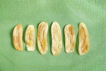 Crispy fried golden sliced banana on green net mat