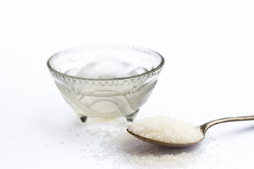 Cube sugar or crystallized sugar with its syrup and mint leaves isolated on white with powder or...
