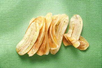 Crispy fried golden sliced banana on green net mat