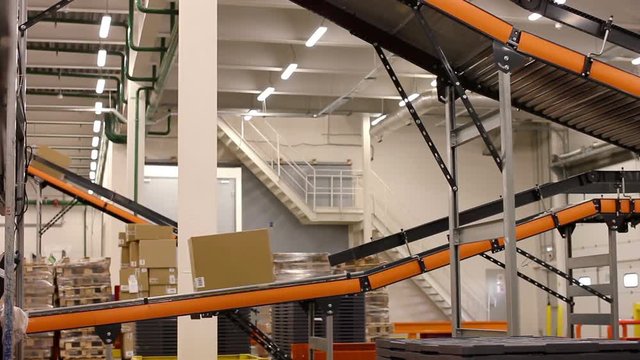 Cardboard boxes on conveyor belt inside warehouse