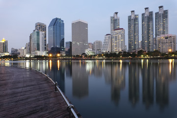 Fototapeta na wymiar les gratte-ciel de bangkok qui se reflètent sur un lac dans la soirée 