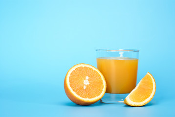 Fresh juice and orange on a blue background with place for a text.