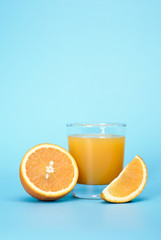 Fresh juice and orange on a blue background with place for a text.