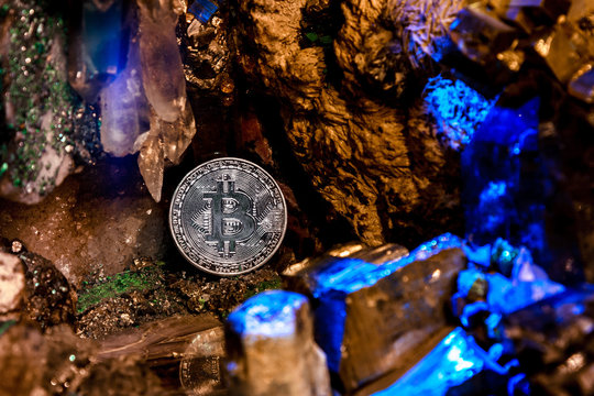 Silver bitcoin in a cave of gem stones