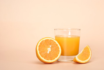 Fresh juice and orange on a beige background with place for a text.