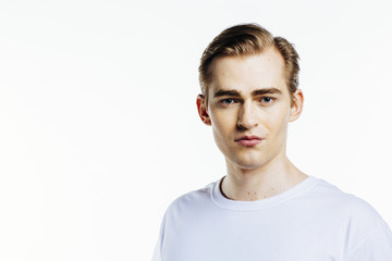Fototapeta na wymiar Portrait of a young expressive man on white studio background