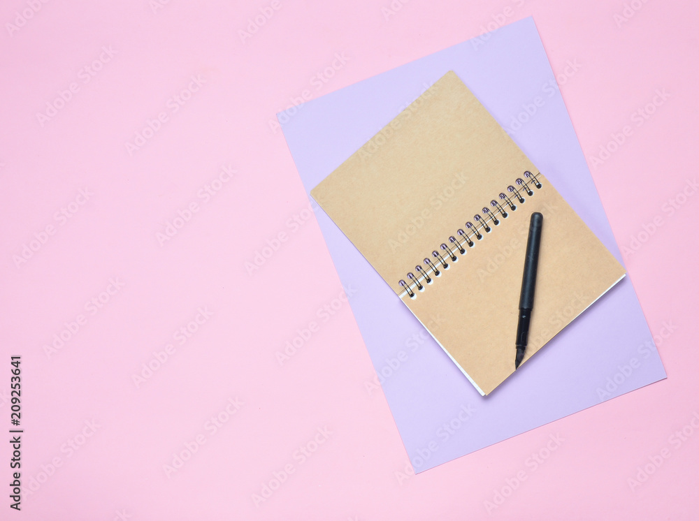 Poster notepad with pen on colored paper background. girly diary. top view..