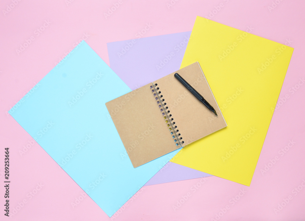 Poster notepad with pen on colored paper background. girly diary. top view..