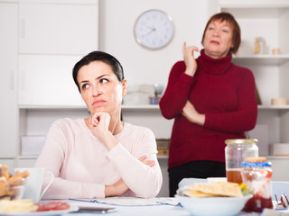 Mature female talking with young sad daughter
