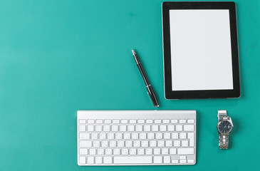 Laptop, tablet and notebook are on a wooden table