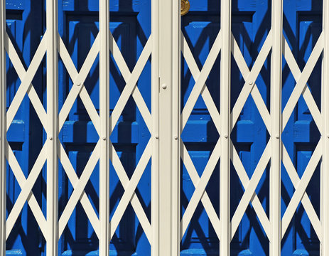 Tienda cerrada con reja de ballesta extensible. Puerta de fondo azul