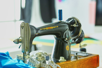 Retro sewing machine on designer clothes desktop