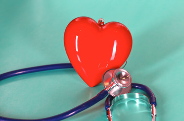 Red heart with stethoscope on blue wooden background. Copy space. Valentines day.