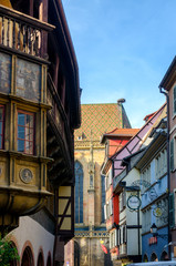Fototapeta premium Cosy narrow colourful street in Colmar going to cathedral, France