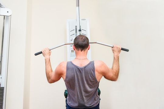 Back View Handsome Fitness Men, Patient At The Physiotherapy Doing Physical Exercises, Training Chest In Sport Rehabilitation. Selective Focus, Copy Space.