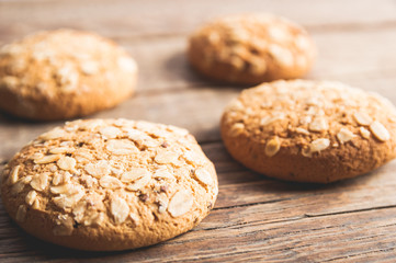 Oatmeal cookies with a sprinkling of oat flakes and seeds on a wooden background