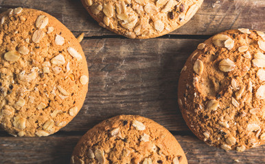 Oatmeal cookies with a sprinkling of oat flakes and seeds on a wooden background