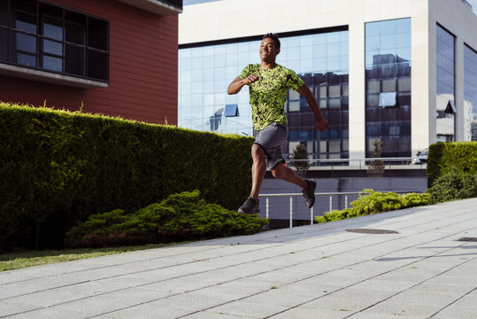 Cheerful sporty ethnic man jumping