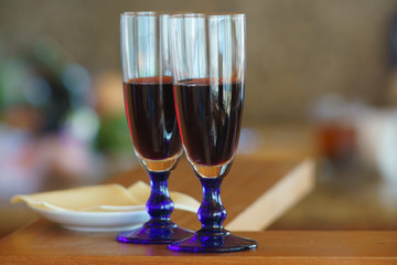 Evening at home, two glasses of red wine and cheese are waiting for someone. Abstract home light bokeh defocused background