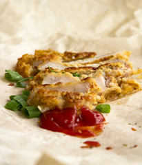 Fresh fried pork chops sprinkled with green onions and ketchup.  Arrangement  on the wrapping paper