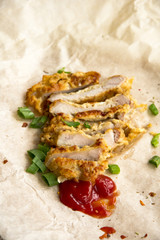 Fresh fried pork chops sprinkled with green onions and ketchup.  Arrangement  on the wrapping paper