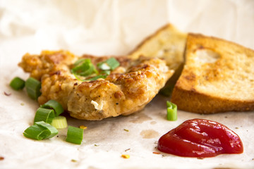 Fresh fried pork chops sprinkled with green onions and ketchup.  Arrangement  on the wrapping paper