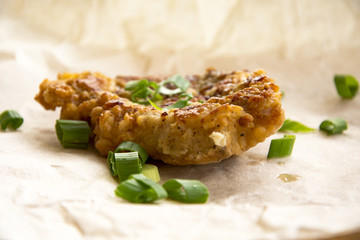Fresh fried pork chops sprinkled with green onions and ketchup.  Arrangement  on the wrapping paper