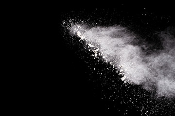  Freeze motion of white dust explosion on black background. Stopping the movement of white powder on dark background. Explosive powder white on black background.