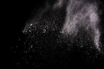  Freeze motion of white dust explosion on black background. Stopping the movement of white powder on dark background. Explosive powder white on black background.