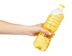 vegetable or sunflower oil in plastic bottle with hand isolated on white background