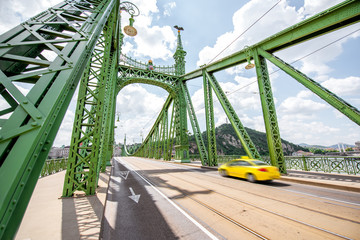 View on the famous Liberty bridge with yellow taxi during the daylight in Budapest, Hungary