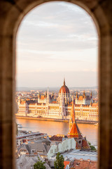 Stadsgezicht door de boog op het beroemde parlementsgebouw tijdens het zonsonderganglicht in Boedapest, Hongarije